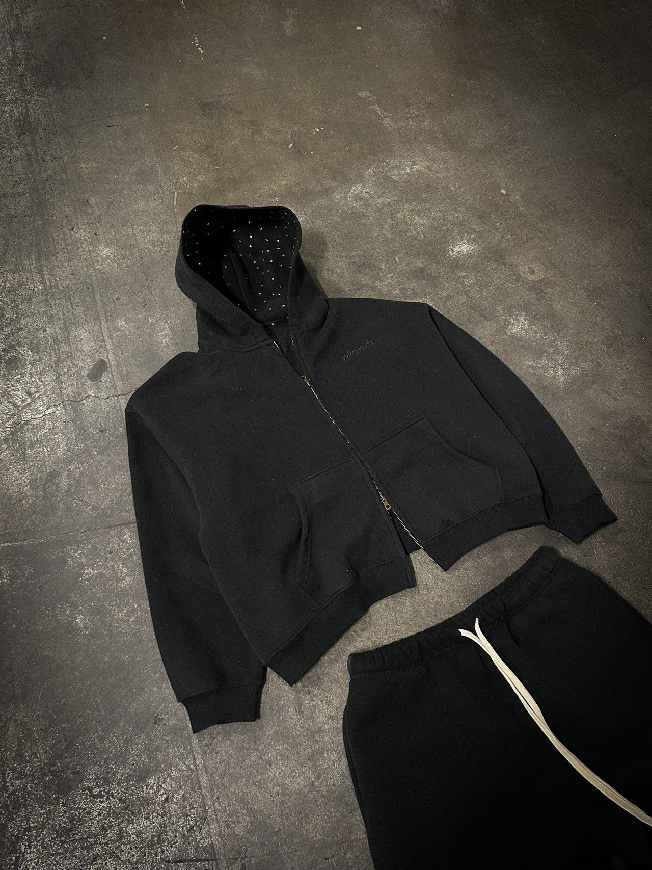 קפוצ׳ון שחור בוקסי עם רוכסן ורקמת Plan T שחורה על שחורה